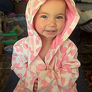 Karsyn joined the competition — help win amazing prizes! toddler, child, robe, hood, pink, white, heart_pattern, smile, indoor, face, cute, person, clothing, sitting, young_child, expression, portrait, warm, happy, eyes
