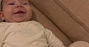 Waylen a rejoint le concours — aidez-le/la à gagner de superbes lots ! baby, bedroom, blanket, cheek, close_up, couch, cozy, fabric, face, hand, happy, home_interior, infant, knee, lying_down, onesie, portrait, skin, smile, soft_texture