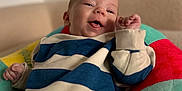 Waylen a rejoint le concours — aidez-le/la à gagner de superbes lots ! baby, infant, smile, striped_sweater, blue_stripes, colorful_seat, cushion, bouncer, hand, face, portrait, closeup, indoors, sofa, happy, cheerful, cozy, soft_background, playful, newborn