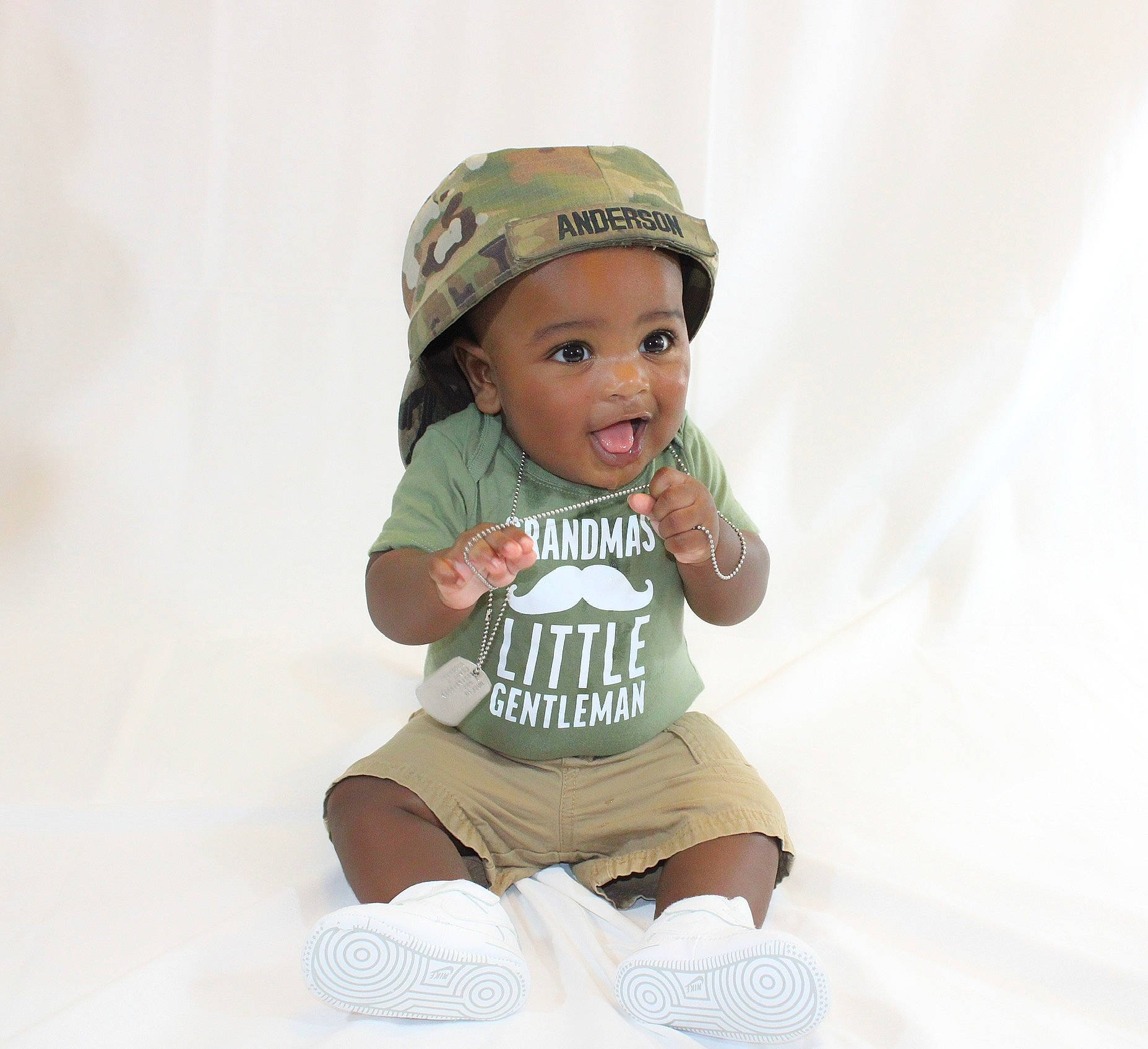 Alijah is registered to the contest to win money with this photo: baby, baby_toddler_clothing, beanie, beige, cap, child, child_model, clothing, headgear, headwear, person, product, sleeve, smile, t_shirt, toddler, white