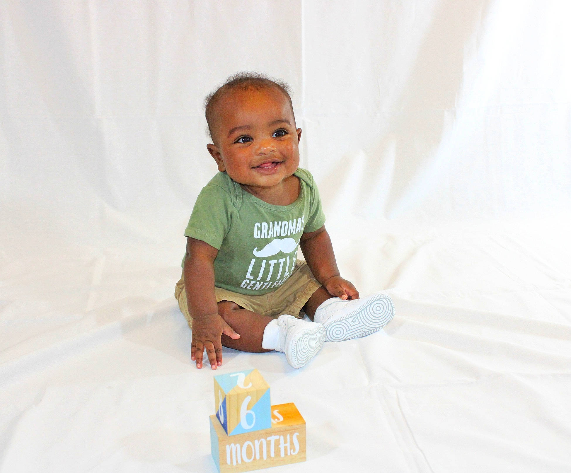 Alijah is registered to the contest to win money with this photo: baby, baby_products, baby_toddler_clothing, child, joy, person, play, product, sitting, skin, smile, t_shirt, toddler, white
