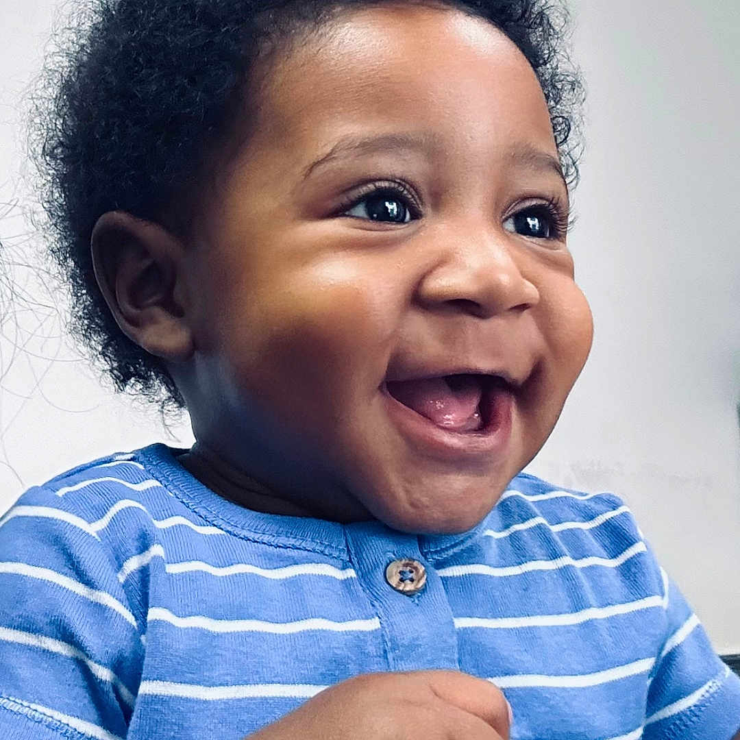 Jiquavious is registered to the contest to win money with this photo: baby, blue_shirt, child, closeup, curly_hair, cute, expression, face, hands, happy, holding, indoor, infant, joy, person, portrait, skin, smile, striped_clothing, young