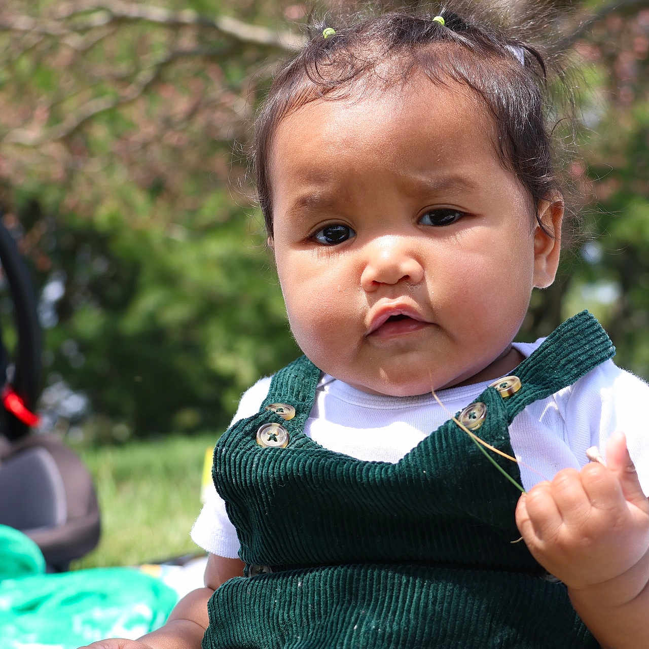 Maria is registered to the contest to win money with this photo: baby, bodypart, car, clothing, dress, face, finger, frown, hand, head, knitwear, person, photography, portrait, sad, sitting, stroller, sweater, transportation, vehicle