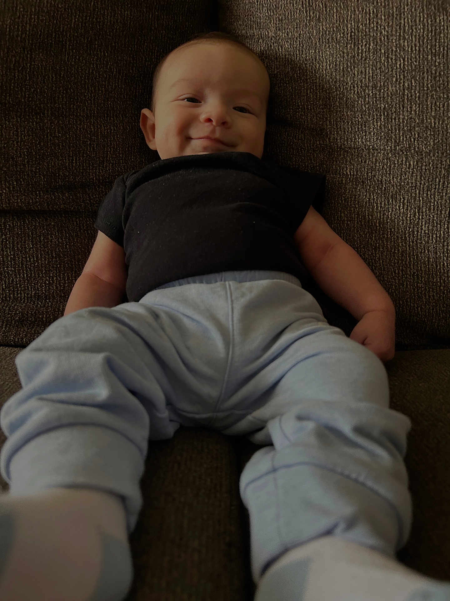 Zavier joined the competition — help win amazing prizes! baby, child, smiling, couch, clothing, pants, shirt, sitting, indoors, person, face, happy, infant, footwear, sock, young, cute, relaxed, portrait, home
