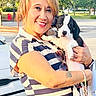 Lola joined the competition — help win amazing prizes! woman, puppy, dog, person, outdoor, parking_lot, trees, car, smiling, holding, striped_shirt, bracelet, tattoo, sunlight, portrait, cute, pet, happy, animal, casual