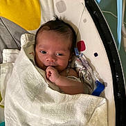 Aziel joined the competition — help win amazing prizes! baby, blanket, infant, face, hand, cushion, pattern, indoor, lying_down, wrapped, cute, newborn, comfort, resting, soft, expression, child, person, young, peaceful