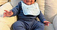 Aziel is registered to the contest to win money with this photo: armchair, baby, beanie, bib, blue_clothing, child, comfort, cozy, cute, face, happy, hat, indoor, infant, knitwear, person, plush_furniture, portrait, sitting, smile