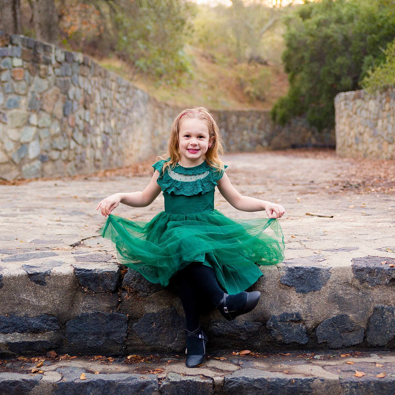 Caylee is registered to the contest to win money with this photo: beauty, blond, child, dress, eye, fun, green, joy, lady, leisure, people, person, photo_shoot, photograph, photography, rock, sitting, smile, stone_wall, tree
