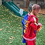 autumn, back_view, blue_jacket, casual_clothing, cheddar, child, colorful_hair, daylight, grass, jacket, leaves, outdoor, park, person, pigtails, playground, red_jacket, slide, snack, young_child