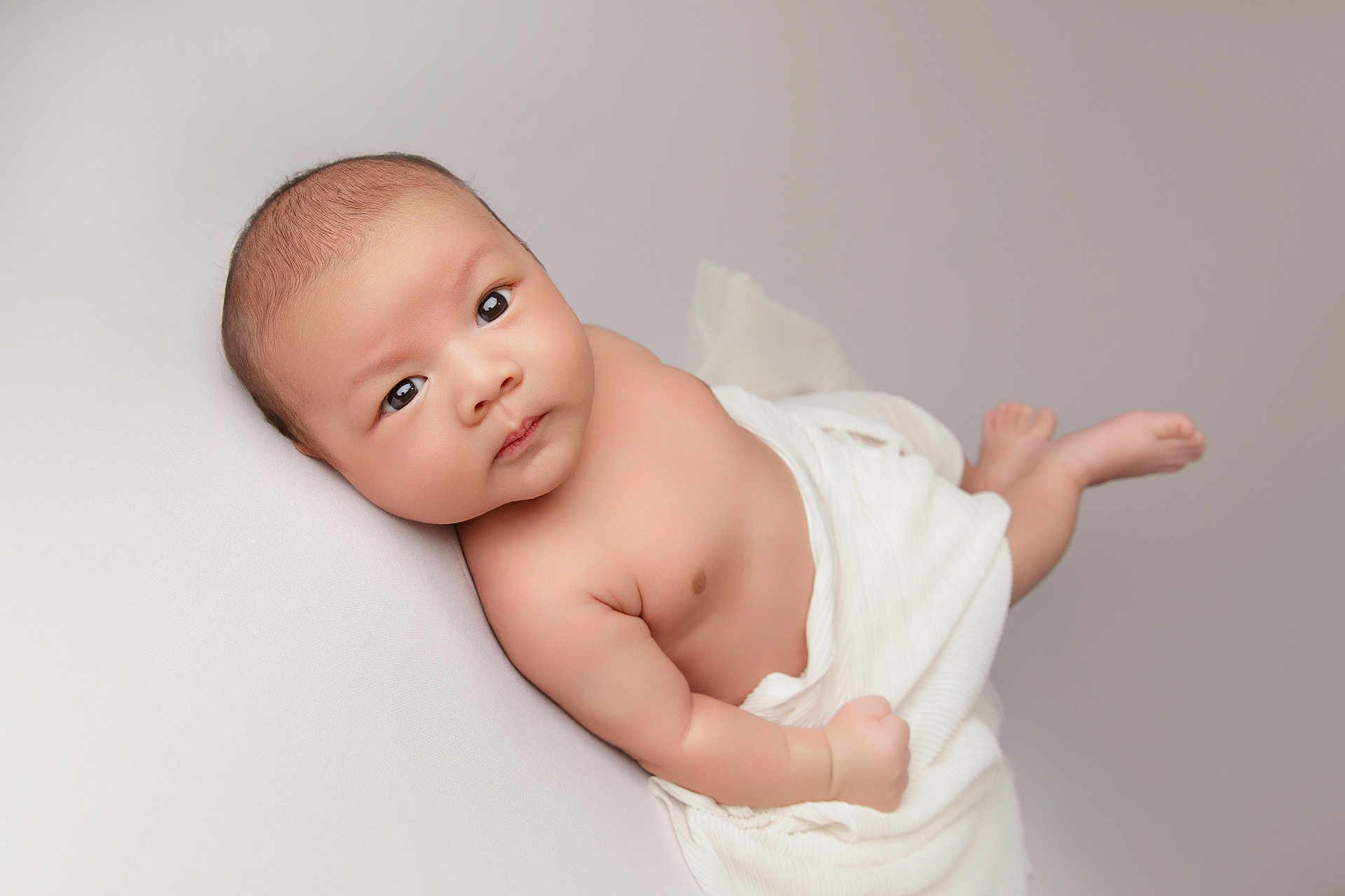 Pranav is registered to the contest to win money with this photo: baby, infant, child, blanket, skin, face, eyes, lying_down, portrait, cute, soft_lighting, newborn, small, peaceful, white, wrapped, indoors, human, expression, baby_boy