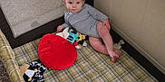 Raiden is registered to the contest to win money with this photo: baby, carpet, child, curious, face, floor, home, indoor, infant, looking, mickey_mouse, onesie, person, plaid, playpen, red_toy, relaxed, small, soft_toy, toys