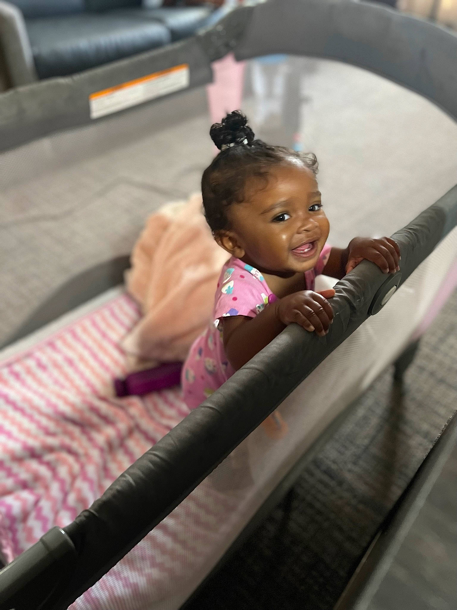 Giselle is registered to the contest to win money with this photo: audio_equipment, baby, baby_products, black_hair, cheek, child, comfort, facial_expression, flash_photography, flooring, fun, happy, leisure, magenta, person, room, sitting, skin, smile, toddler