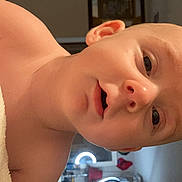Elijah is registered to the contest to win money with this photo: baby, infant, child, face, skin, towel, indoor, room, furniture, mirror, curtains, light, ring_light, portrait, expression, human, person, head, cute, baby_skin