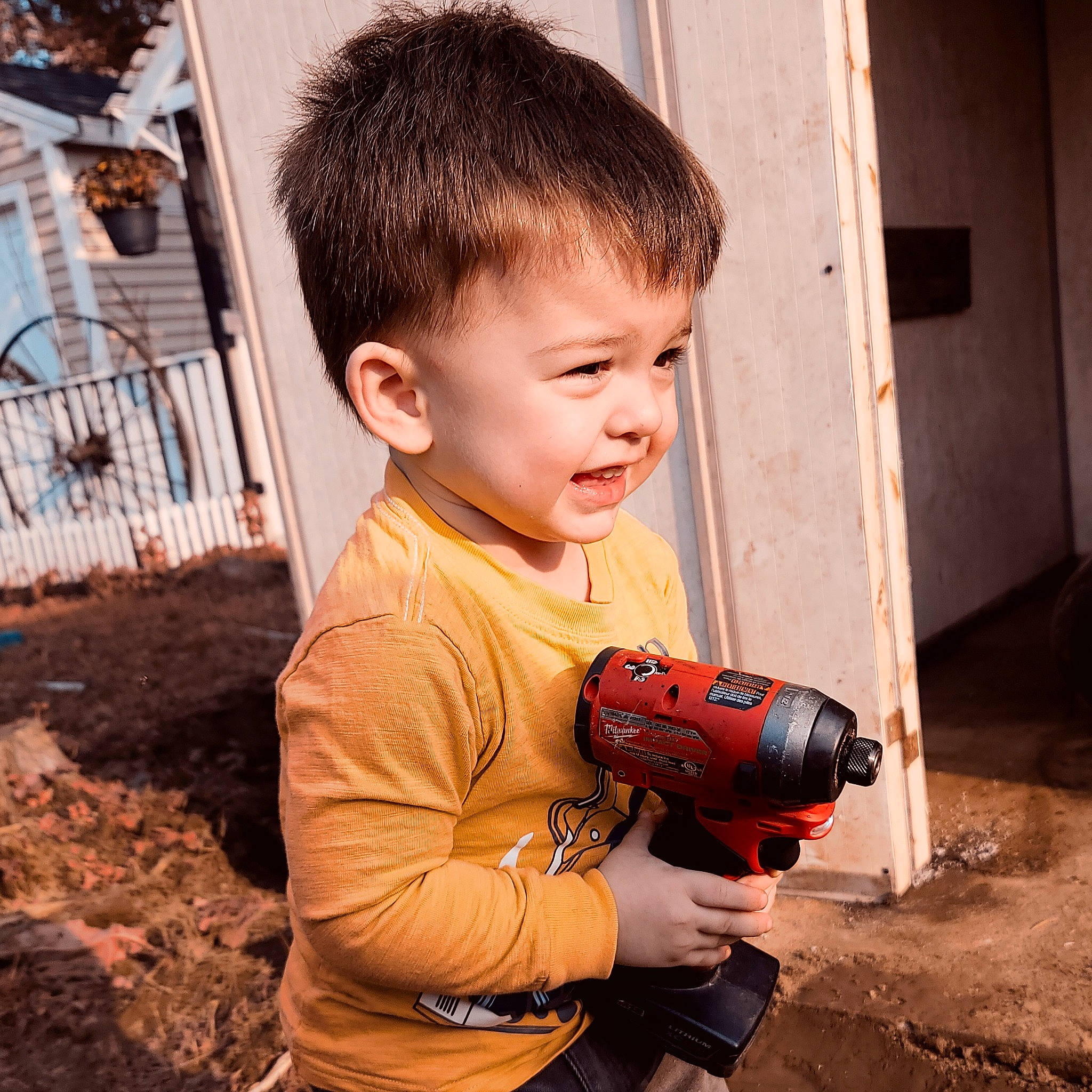 Jaxxon is registered to the contest to win money with this photo: cameras_optics, carmine, child, drill, flash_photography, flooring, fun, gadget, happy, person, personal_protective_equipment, play, power_tool, sitting, sleeve, soil, t_shirt, toddler, tool, toy