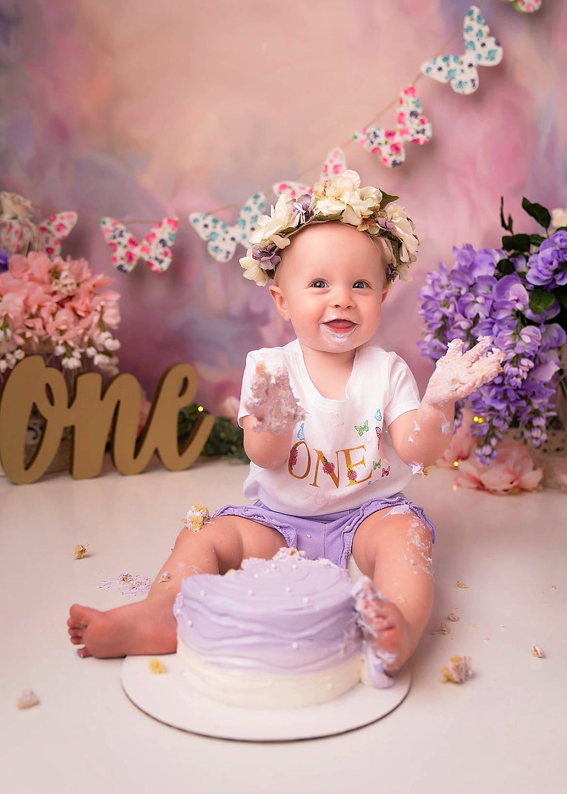 Aspen is registered to the contest to win money with this photo: baby, baby_toddler_clothing, child, event, fashion_accessory, flash_photography, fun, hair_accessory, happy, hat, headband, headpiece, joy, peach, person, petal, pink, purple, smile, sugar_cake