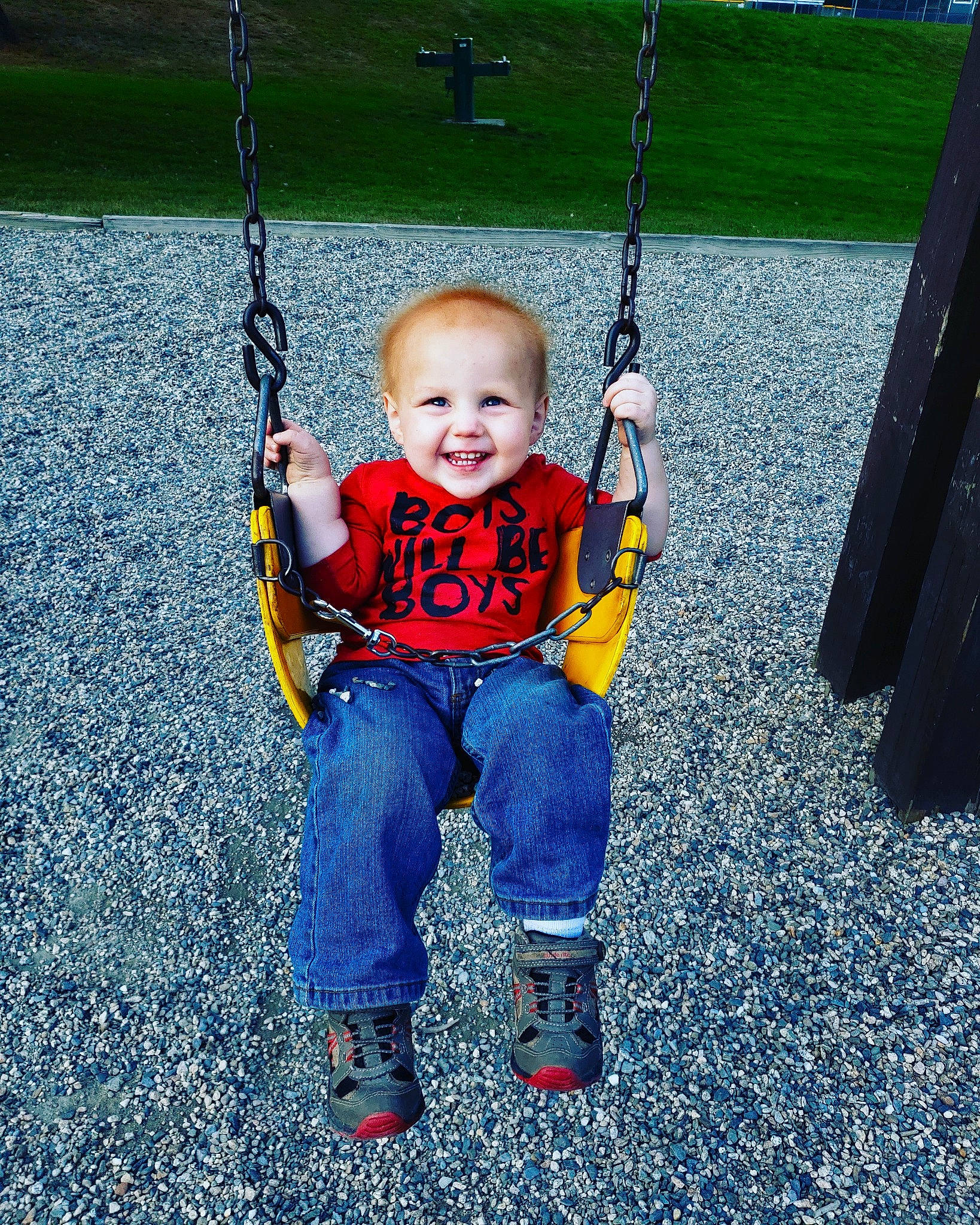 Dana is registered to the contest to win money with this photo: baby, child, city, fun, jeans, joy, outdoor_play_equipment, person, plant, play, playground, public_space, recreation, smile, swing, toddler, tree, vacation