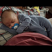 Zayvion is registered to the contest to win money with this photo: baby, blanket, child, closeup, comfort, cozy, cute, home, indoor, infant, newborn, onesie, pacifier, peaceful, plaid_blanket, portrait, relaxing, resting, sleeping, soft_lighting