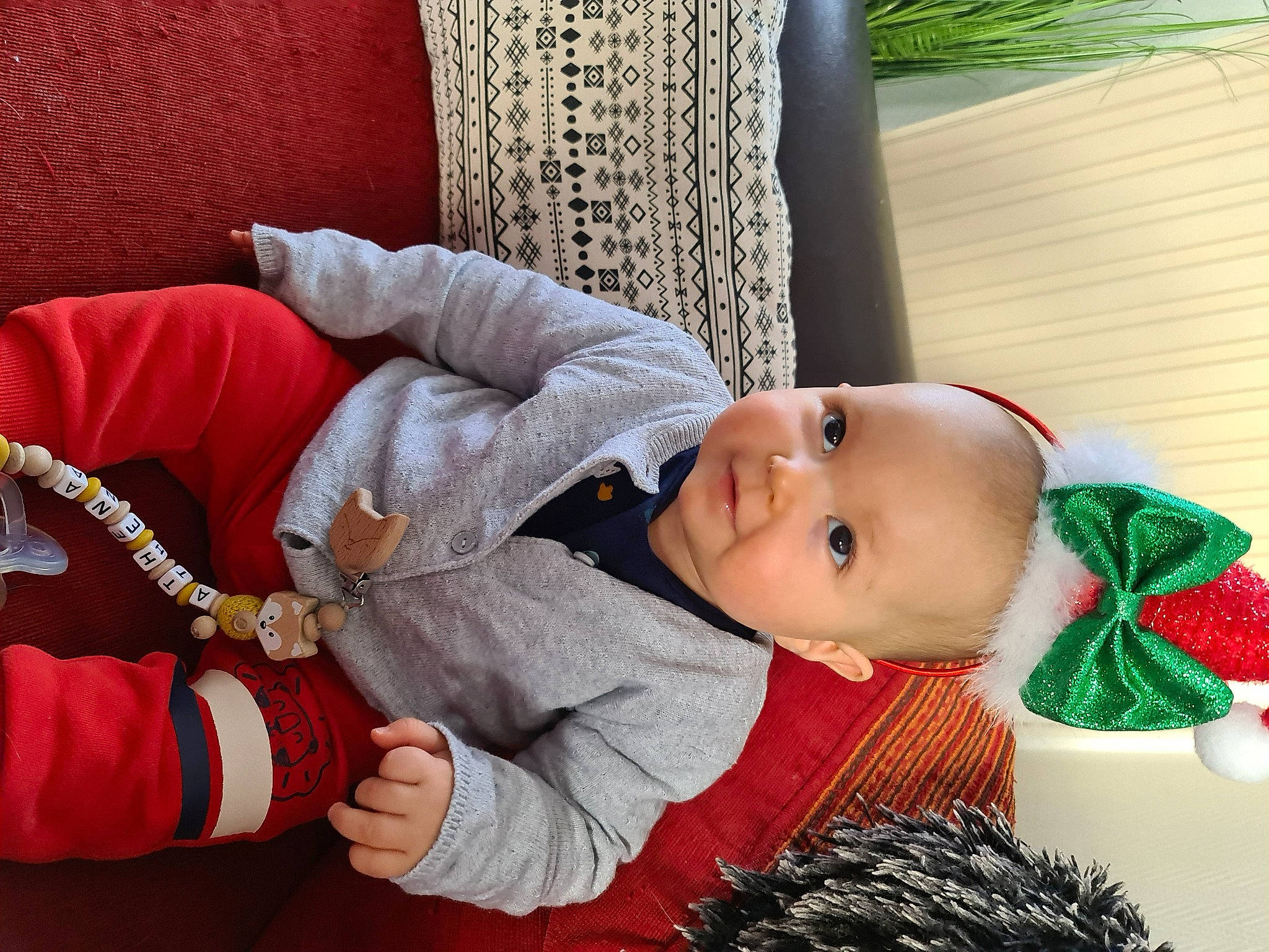 Athena participe au concours pour gagner de l'argent avec cette photo : baby, baby_toddler_clothing, cheek, child, christmas, comfort, flooring, fur, headgear, human_body, lap, pattern, person, room, sitting, skin, textile, toddler, toy, wood