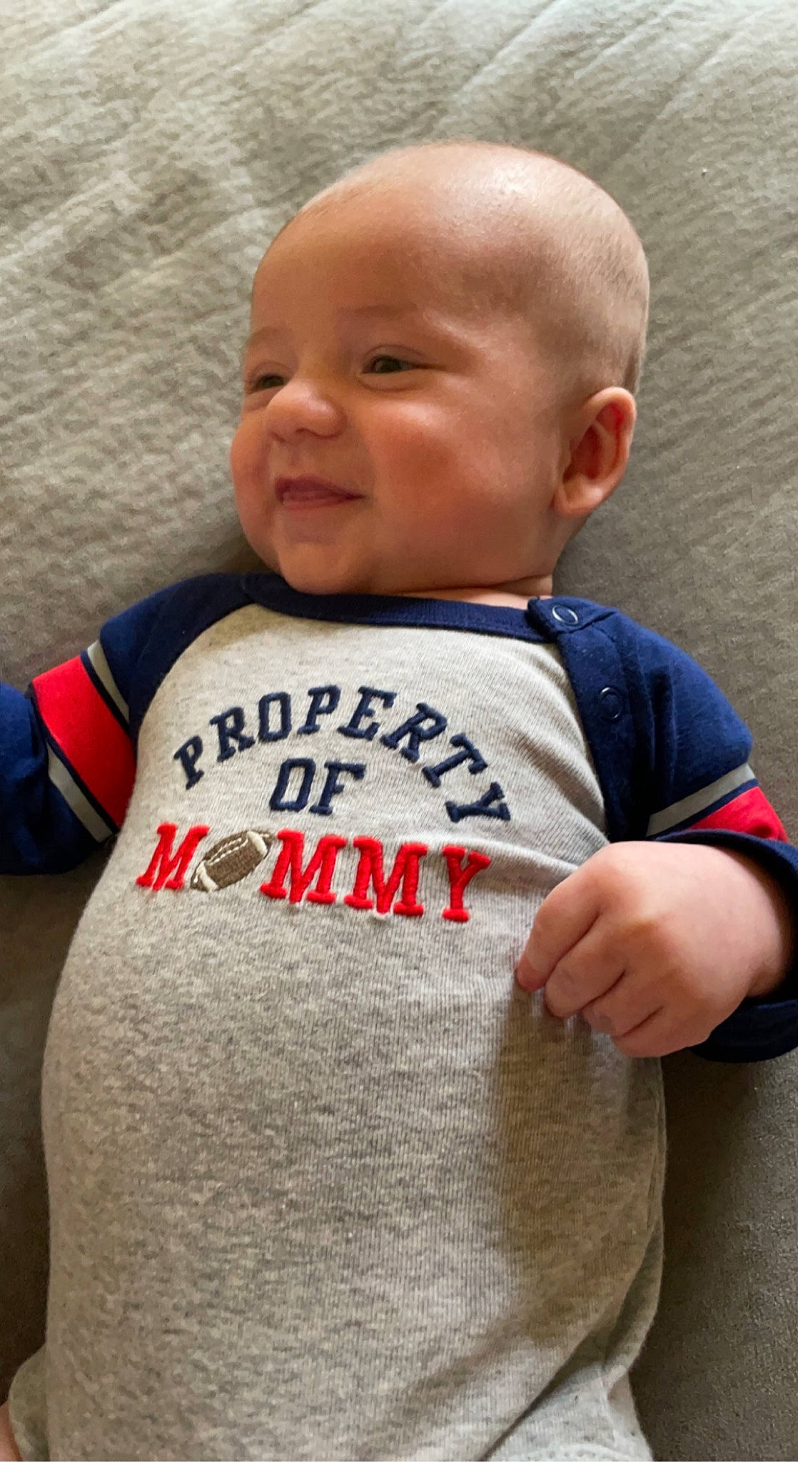 Kaiden is registered to the contest to win money with this photo: arm, baby, baby_toddler_clothing, cheek, chin, eye, eyebrow, face, hair, happy, human_body, neck, nose, outerwear, person, product, skin, sleeve, smile, standing