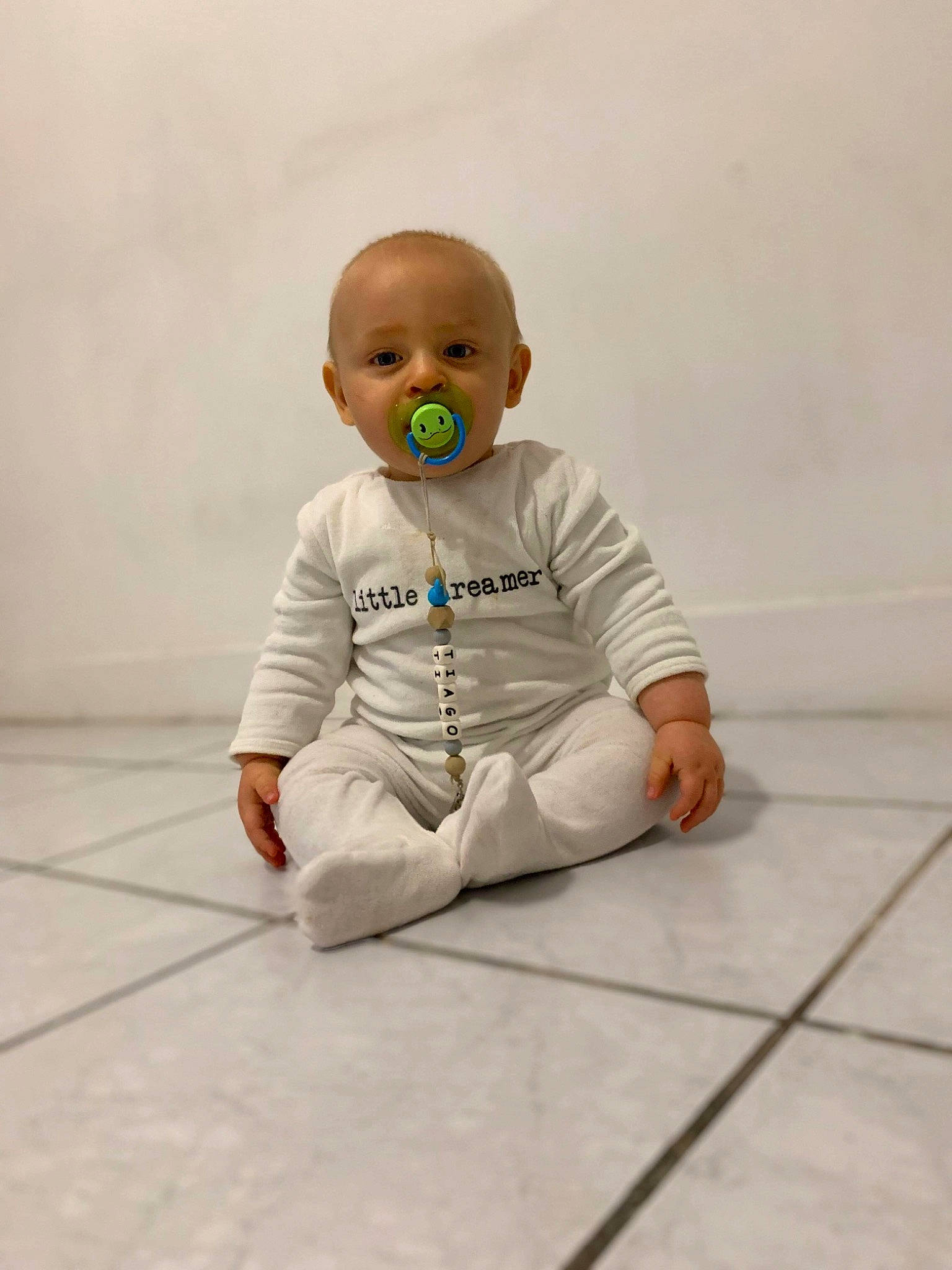 Tiago participe au concours pour gagner de l'argent avec cette photo : baby, cheek, child, crawling, floor, flooring, head, joint, person, sitting, sleeve, toddler, white