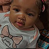 Armani Grace is registered to the contest to win money with this photo: baby, child, infant, onesie, hair_ties, pink, white_clothing, face, portrait, indoors, blanket, cute, screenshot, phone_interface, playback_controls, app_icons, seated, expression, soft_toys, colorful