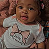 baby, infant, child, cute, smiling, hair_ties, blanket, shirt, text, face, eyes, screenshot, mobile_phone_interface, gallery, playback_controls, portrait, indoors, soft_texture, happy, person
