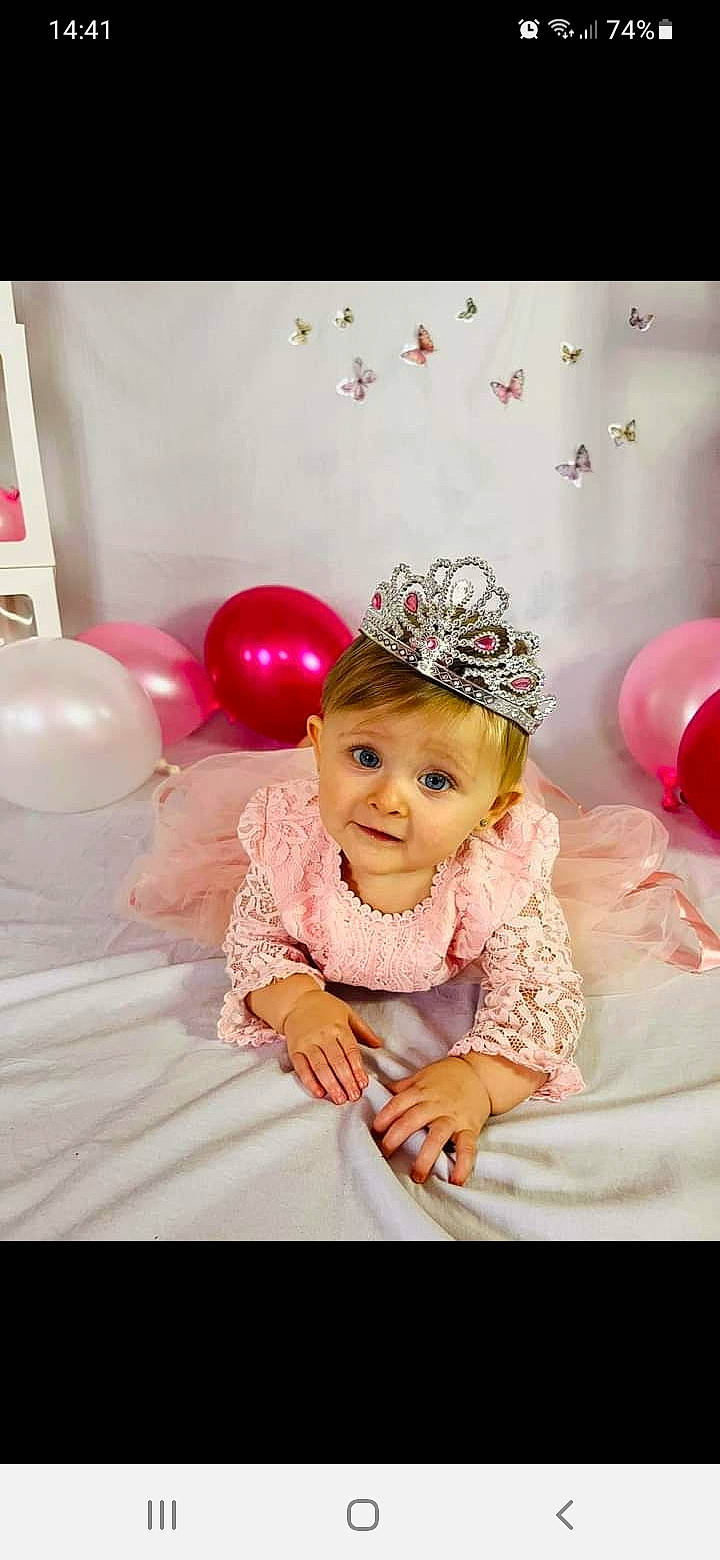 Mia a rejoint le concours — aidez-le/la à gagner de superbes lots ! baby, baby_toddler_clothing, balloon, birthday, birthday_party, child, costume_hat, event, fun, hair_accessory, happy, headgear, headpiece, headwear, magenta, party_supply, peach, person, petal, pink