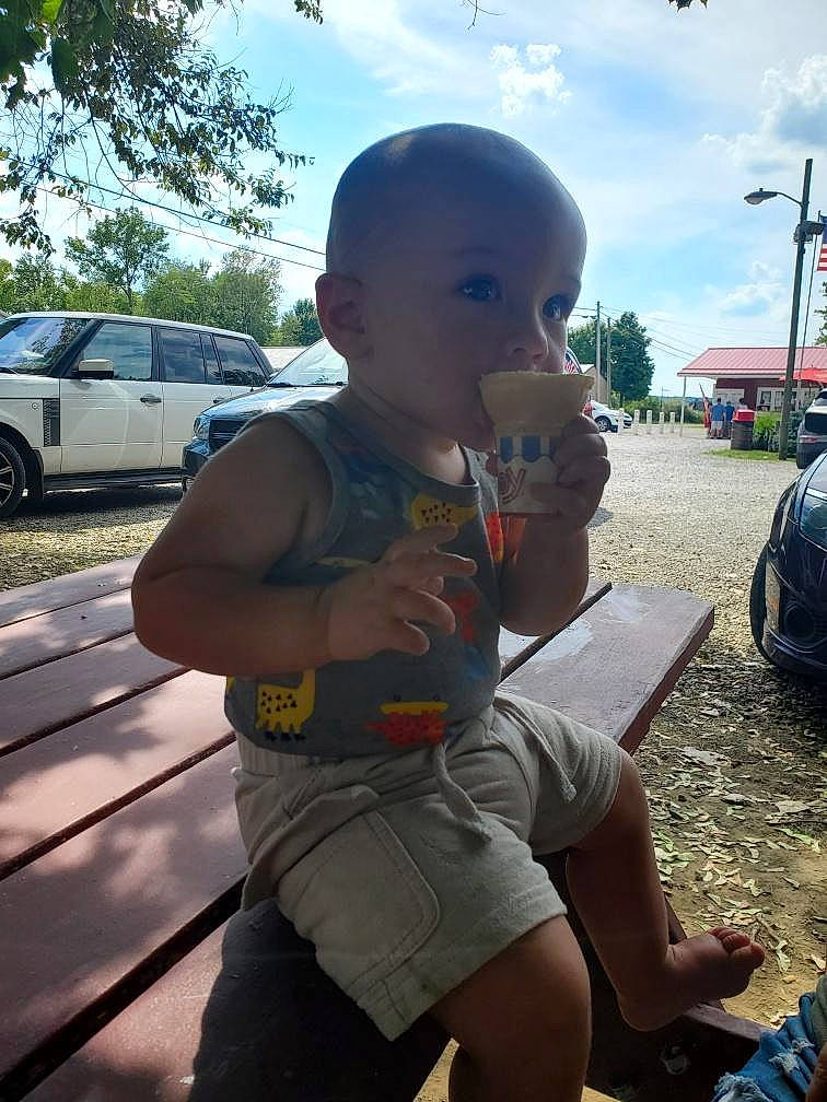 Reed is registered to the contest to win money with this photo: asphalt, automotive_exterior, automotive_tire, car, chest, cloud, cool, eyewear, grass, leisure, motor_vehicle, person, public_space, shorts, sky, summer, thigh, tire, tree, trunk