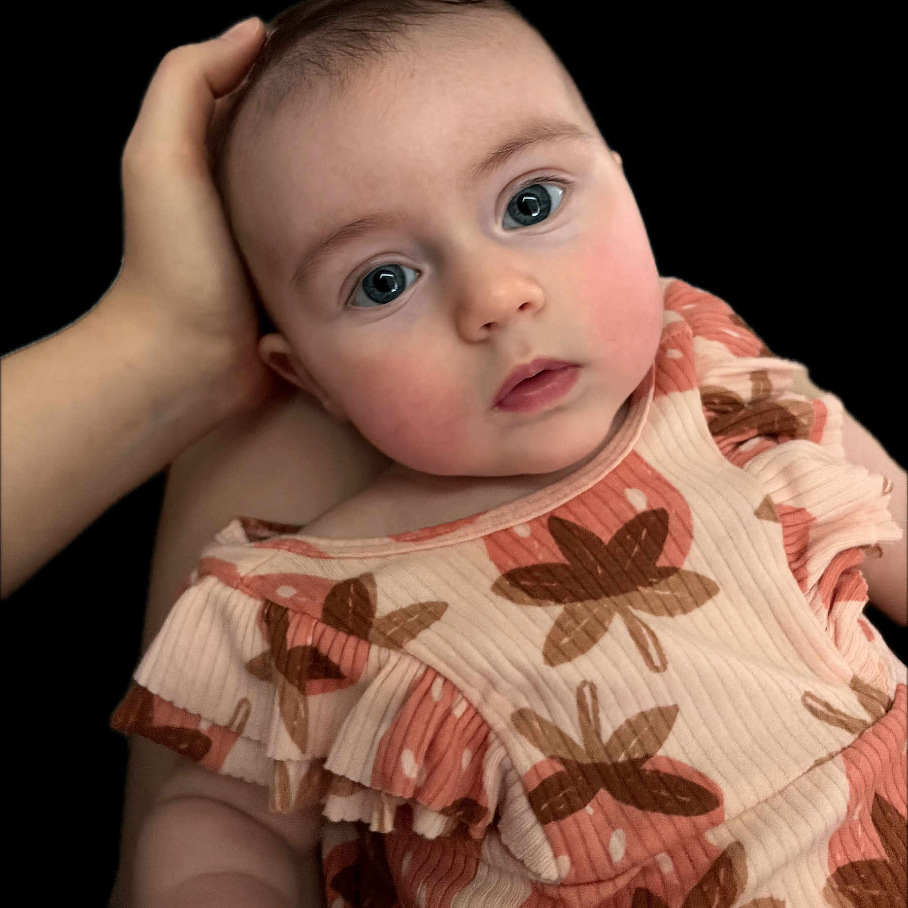 Genevieve is registered to the contest to win money with this photo: baby, infant, face, hand, portrait, cute, child, clothing, pattern, flower, skin, rosy_cheeks, eyes, close_up, soft_lighting, expression, young, person, head, background