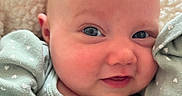 Hazel joined the competition — help win amazing prizes! baby, infant, face, blue_eyes, smile, green_clothing, hearts_pattern, blanket, cozy, close_up, cute, newborn, soft_texture, skin, person, portrait, child, warm, resting, happy