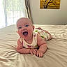 Hazel is registered to the contest to win money with this photo: baby, smiling, bed, indoor, curtains, painting, happy, infant, child, room, natural_light, blanket, clothing, portrait, skin, person, head, cheerful, cute, furniture