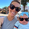 Hazel joined the competition — help win amazing prizes! woman, baby, sunglasses, outdoor, sunny, blue_sky, tree, headband, smile, baby_clothing, woman_clothing, park, daylight, portrait, people, child, happy, casual, accessory, nature