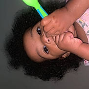 Amira joined the competition — help win amazing prizes! child, toddler, face, hand, curly_hair, spoon, green_spoon, blue_spoon, skin, indoors, close_up, expression, person, baby, young_child, curiosity, holding, playing, portrait, casual