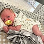 Dylan is registered to the contest to win money with this photo: newborn, baby, pacifier, crib, blanket, infant, sleeping, patterned, star_pattern, clothing, soft_toys, resting, cute, indoors, toddler, face, human, skin, lying_down, comfort