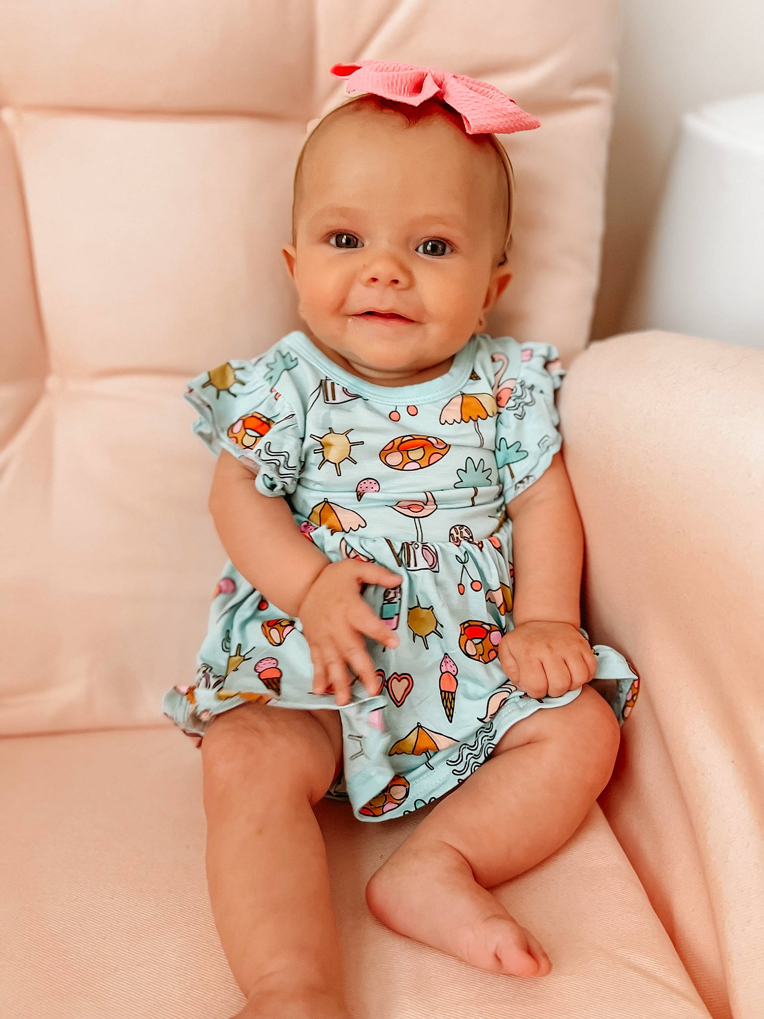 Elleri is registered to the contest to win money with this photo: arm, baby, baby_toddler_clothing, cheek, dress, eye, face, finger, happy, head, iris, joy, lip, neck, one_piece_garment, person, pink, skin, sleeve, smile