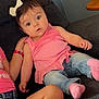 baby, child, girl, pink_top, jeans, white_bow, couch, indoor, curious, wide_eyes, casual_clothing, sitting, socks, hand, arm, leg, dark_gray, furniture, portrait, family