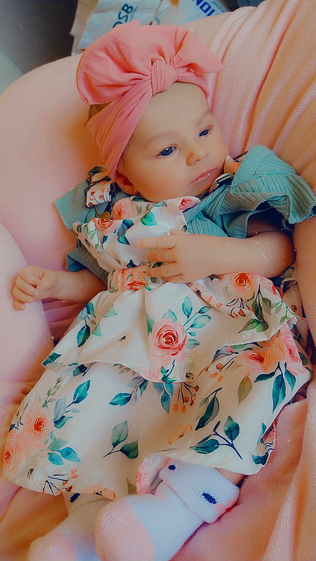 Lénaëlle a rejoint le concours — aidez-le/la à gagner de superbes lots ! baby, infant, pink_bow, headband, floral_dress, socks, blue_eyes, cute, child, soft_texture, cushion, relaxing, indoors, portrait, small_hands, small_feet, resting, comfortable, colorful_clothing, peaceful