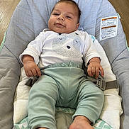 Aziel is registered to the contest to win money with this photo: baby, infant, baby_seat, clothing, mint_green, white_shirt, bear_print, face, feet, hands, wood_floor, cushion, comfort, indoor, child, portrait, happy, smiling, relaxed, toddler