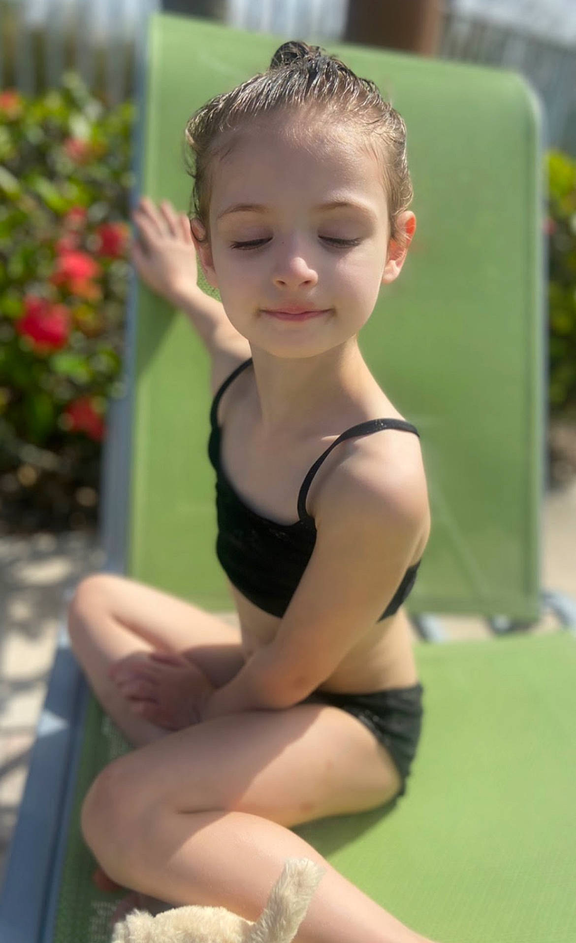 Madison is registered to the contest to win money with this photo: chest, child, eye, face, facial_expression, fun, grass, hair, happy, head, human_leg, leg, leisure, neck, person, plant, smile, sportswear, thigh, toddler