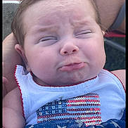Oakley joined the competition — help win amazing prizes! baby, face, pout, close_up, expression, child, infant, clothing, sequins, american_flag, stars, blue, white, red, person, hand, outdoor, cute, portrait, toddler