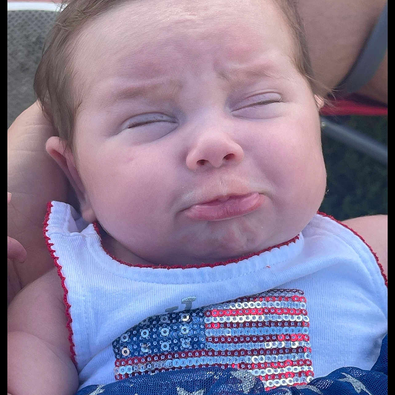 Oakley joined the competition — help win amazing prizes! baby, face, pout, close_up, expression, child, infant, clothing, sequins, american_flag, stars, blue, white, red, person, hand, outdoor, cute, portrait, toddler