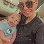Sawyer joined the competition — help win amazing prizes! baby, woman, smiling, sunglasses, car, seat, holding, shirt, yin_yang, face, portrait, happy, casual, indoors, sparkles, light_effects, person, parent, child, cute