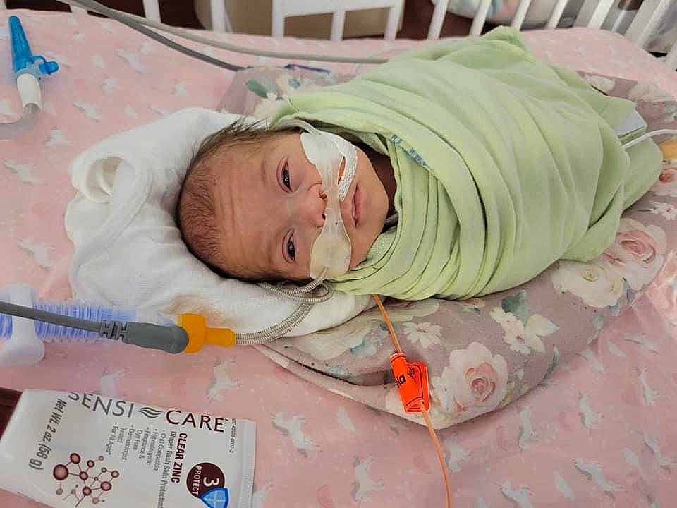 Alice is registered to the contest to win money with this photo: baby, baby_products, baby_safety, baby_toddler_clothing, bed, bedtime, child, childbirth, comfort, event, eye, hospital, infant_bed, kitchen_utensil, linens, medical_equipment, person, room, skin, smile