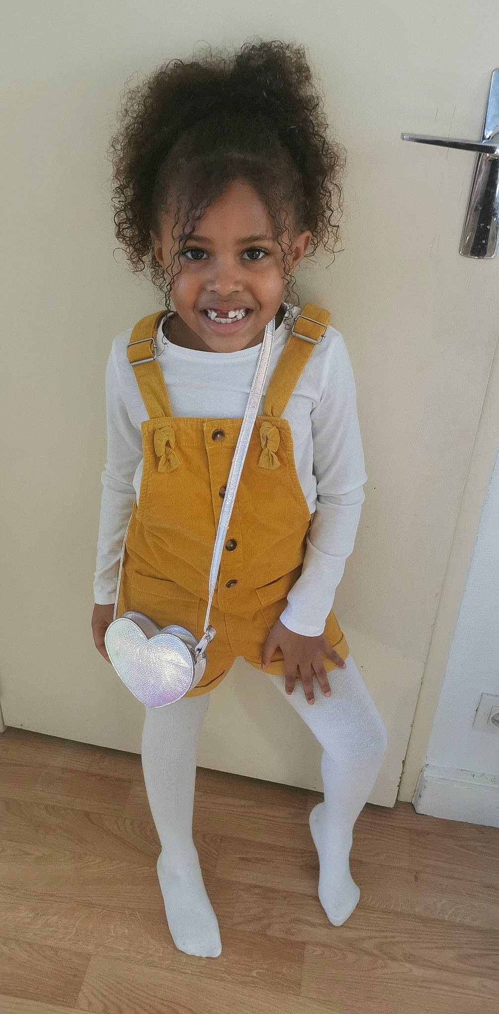 Inaya participe au concours pour gagner de l'argent avec cette photo : afro, arm, baby_toddler_clothing, face, flooring, gesture, glove, hair, happy, human_body, joint, joy, knee, neck, person, skin, sleeve, smile, standing, thigh