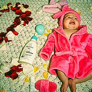Ariani joined the competition — help win amazing prizes! baby, pink_robe, flower_petals, number_two, blanket, baby_care_products, bottle, baby_bottle, baby_girl, happy_baby, lying_down, indoors, celebration, soft_texture, toddler, smiling, headwear, baby_accessory, cute, infant