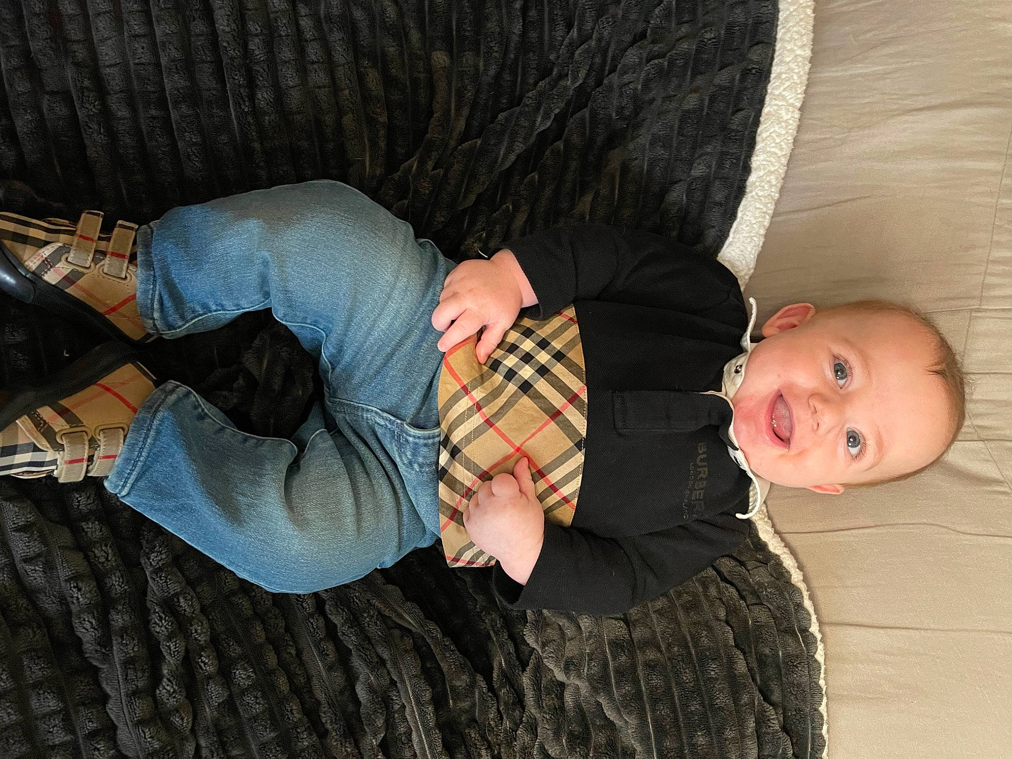 Brantley joined the competition — help win amazing prizes! baby_toddler_clothing, comfort, couch, finger, human_body, human_leg, joint, knee, lap, leg, mammal, person, plaid, sitting, smile, tartan, textile, thigh, toddler, trunk
