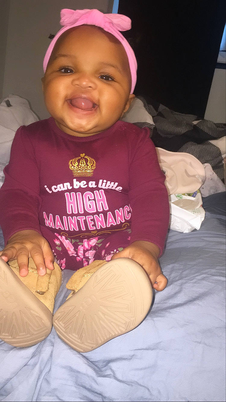 Caioir is registered to the contest to win money with this photo: arm, baby, baby_toddler_clothing, cheek, comfort, eye, face, facial_expression, head, human_body, lip, mammal, mouth, nose, organ, person, purple, skin, sleeve, smile