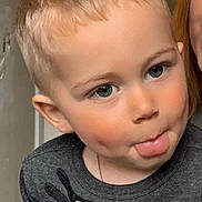 Jules a rejoint le concours — aidez-le/la à gagner de superbes lots ! child, toddler, blonde_hair, dimples, tongue_out, sweater, indoor, playful, face, portrait, cute, young, person, expression, smile, head, clothing, light, happy, closeup