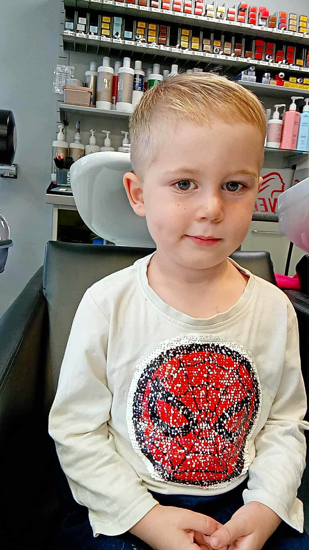 Jules a rejoint le concours — aidez-le/la à gagner de superbes lots ! child, boy, haircut, shirt, spiderman, sequin, salon, chair, bottle, product, shelf, haircare, indoor, casual_clothing, short_hair, portrait, sitting, cute, kid, young