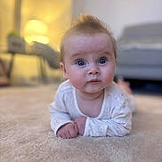 Freya joined the competition — help win amazing prizes! baby, infant, carpet, floor, indoors, curious, lying_down, soft_lighting, living_room, furniture, blurred_background, toddler, cute, person, portrait, child, home, cozy, expression, face